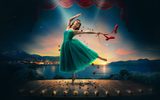 A ballerina in a teal tutu dances on stage under a spotlight, while red ballet shoes and rose petals float around her. A sunset over a lake is visible in the background.