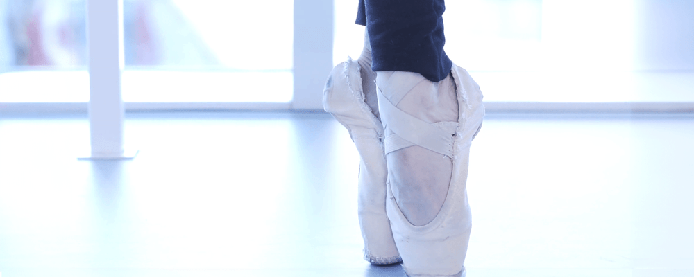A close up on the feet of a ballet dancer en pointe